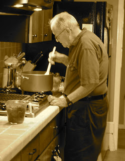Elderly man stirring a pot of soup on the stove